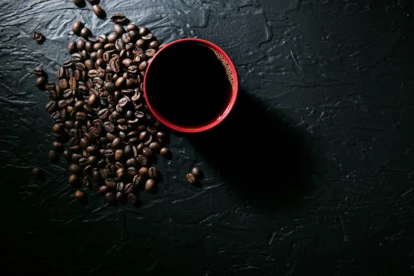 Kahve fincanı ve kahve çekirdekleri siyah arka planda