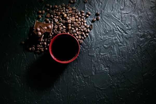 Coffee cup and coffee beans and chocolate on black background — Stock Photo, Image