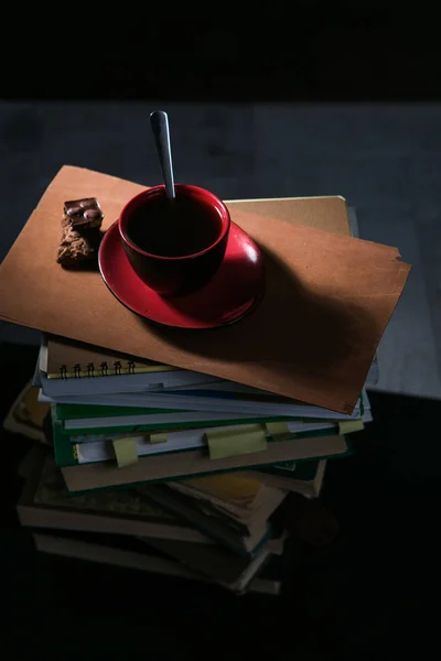 Kaffeetasse und Kekse und Schokolade auf Bücherstapel — Stockfoto