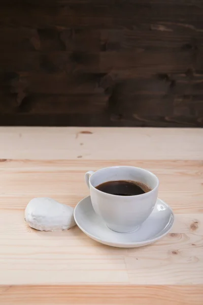 Taza de café blanco y pan de jengibre en escritorio de madera — Foto de Stock