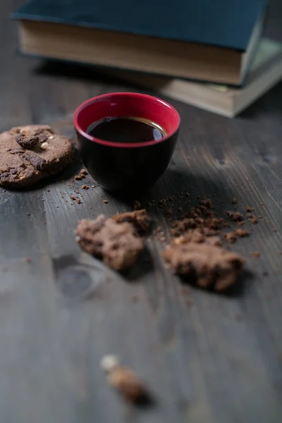 Xícara de café e biscoitos estão ao lado da pilha de livros — Fotografia de Stock