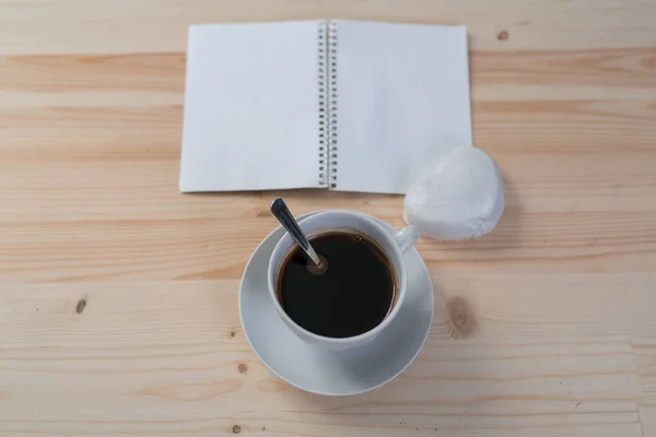 Una taza de café, pan de jengibre y un bloc de notas sobre una mesa de madera —  Fotos de Stock