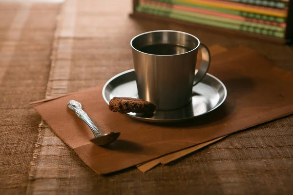 Kaffeetasse mit Löffel und Keksen auf dem Hintergrund von Notizbüchern — Stockfoto