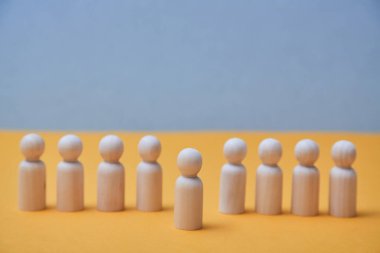 Alışılmışın dışında düşünüyorum. Bireysel yaklaşım. Liderlik ve bireysellik. Tahta insan figürü kalabalıktan göze çarpar.