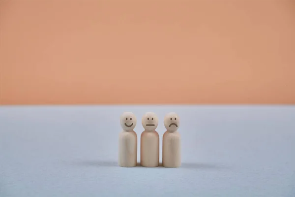 Emotions of people. Positive, negative, neutral attitude. Wooden persons figures with smile, sad and indifferent emoji — Stock Photo, Image