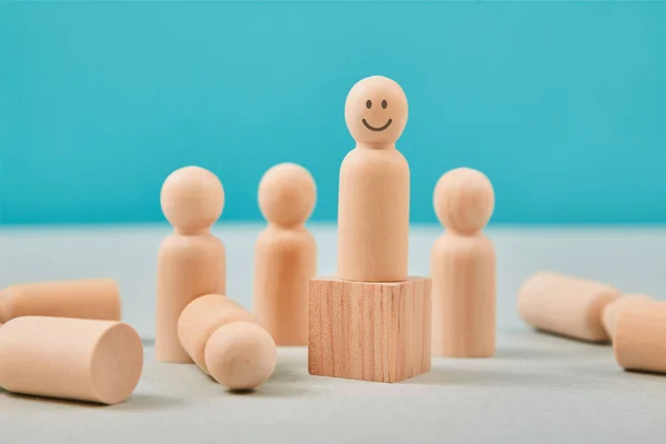 Pozitif düşünce, tavır. Pozitif olmak. Olumsuz düşünmek yok. Tahta insan figürü gülümsemeli emoji küpün üzerinde duruyor.