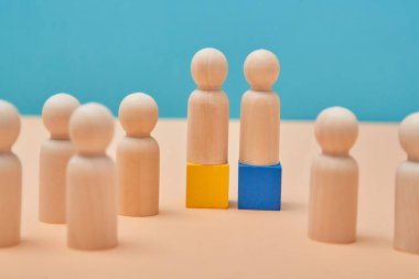 Takım çalışması modellemelerinde liderlik. Kazanma ve üstünlük şablonu. Ahşap takım liderleri renkli bloklarda duruyorlar