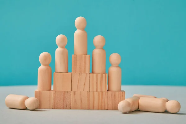 Företagshierarki. Hierarkisk företagsorganisation. Pyramid av träblock, små människor på trappor och på golvet — Stockfoto