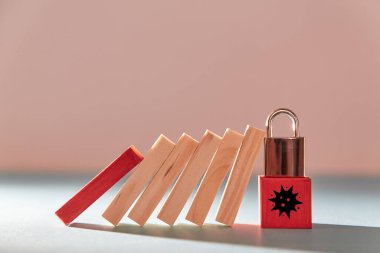 Küresel Ekonomik kriz. Coronavirus 'u durdurun. Önleyici önlemler. Asma kilitli ahşap küp domino etkisini durdurdu.