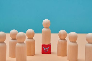 Business hierarchy. Ranking and leadership. Person miniature standing among people on red wooden cube with crown sign clipart