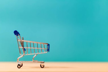 Boş market arabası minyatür sembolü. Küçük metal tramvay. Alışveriş ve mal satın alma. Perakende ve toptan satış. Boşluğu kopyala