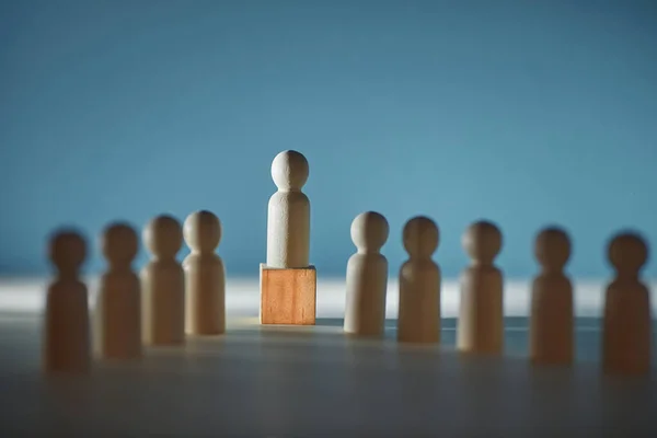 Trä figurer av människor på nyanser bakgrund. Ledare miniatyr på kub, kopiera utrymme. Mall för modellering av skuggekonomin — Stockfoto