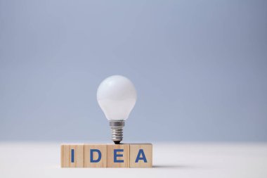 Yaratıcı fikir üretimi. Yaratıcılık ve yenilik. Yaratıcı düşünce. Tahta küpler, fikir yazıları ve ampul.