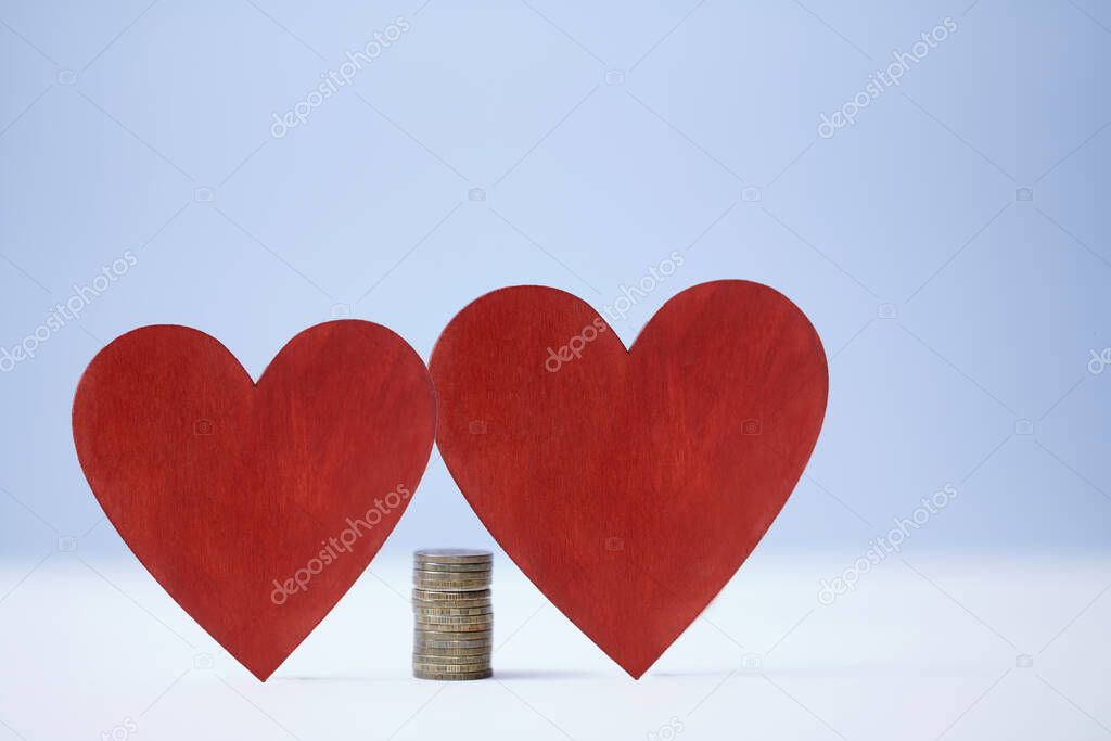 Family vs career growth. Price of love. Relationship versus wealth. Red hearts and stack of coins in center, copy space
