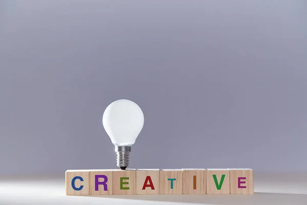 Kreative Ideenfindung. Innovation und Kreativität. Einsicht und originelles Denken. Holzwürfel, Glühbirne oben drauf — Stockfoto