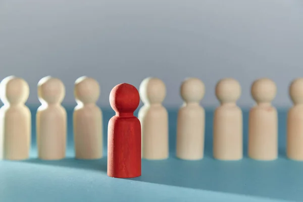 Figuras en blanco de madera en línea y una roja por delante. Destaca entre la multitud. Piensa fuera de la caja. No como todo el mundo. Copiar espacio —  Fotos de Stock