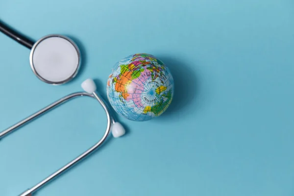 Globe and medical stethoscope. Global healthcare mockup. World medicine, place for text. Isolated on blue background