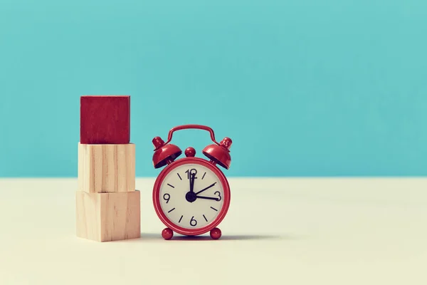 Stack of cubes with one red on top and alarm clock. Time is money mockup. Time-limit. Business deadline. Copy space — Stock Photo, Image