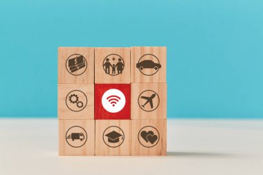 Çevrimiçi kamu hizmeti. E-ödemeler. Merkezinde kırmızı blok olan tahta küpler, kablosuz internet, araba, kalp, uçak işaretleri
