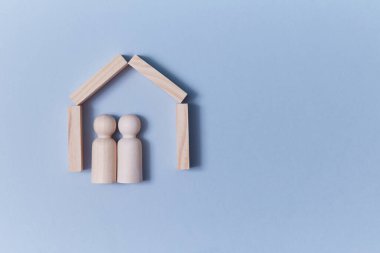 İçinde insan figürleri olan ahşap ev, kopyalama alanı. Gayrimenkul yatırım modeli. İpotek. Emlak almak, satmak.