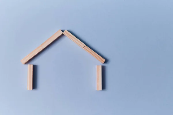 Serviços de garantia. Seguro de propriedade. Protecção. Casa miniatura de tábuas de madeira. Lugar para SMS. Isolado em azul — Fotografia de Stock