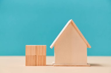 Boş ahşap ev ve kare şeklinde tahta küpler. Yaratıcı tasarım için blokları olan boş şablon, kopyalama alanı