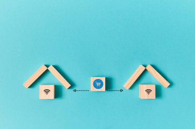 İnternetten alışveriş. E-mağaza. Çevrimiçi süpermarket. Tramvay işaretli ahşap küp ve mavi üzerinde izole edilmiş evler arasında oklar.