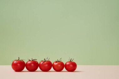 Açık bej zeminde olgun kırmızı domatesler. Sağlıklı bir yaşam tarzı. Diyet yemek. Uzayı kopyala Pastel yeşil arkaplan