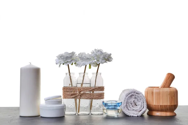 Wooden mortar tubes with cream. Candles and white towel. Aromatic oils. Spa day. Skincare. White backdrop. Copy space