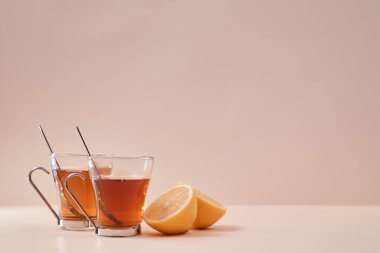 Çay seremonisi. Çay zamanı. Kupaların etrafına limonlu meyve ve çay karışımı. Uzayı kopyala Pembe arka planda izole edilmiş