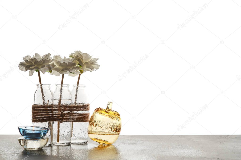 Aromatic oils and glass candleholder. Wellness. Skincare and beauty concept. Copy space. Isolated on white background