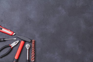 Kesici çekiç ve kerpeten. Bina. İnşaat alanı. Tamir konsepti. İşçi bayramı. Uzayı kopyala Koyu arkaplan