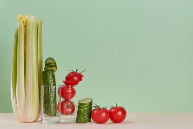 Kereviz salatalığı ve domates. Çevre dostu yemek. Diyet olsun. Sağlıklı bir yaşam tarzı. Uzayı kopyala Pastel yeşil arkaplan