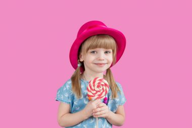 Isolated on bright background, studio. Beautiful little girl with lollipop clipart