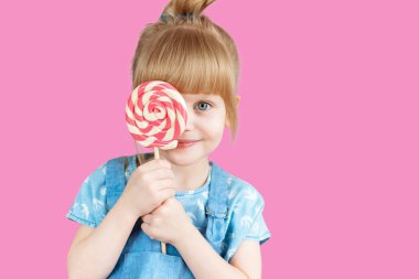 Isolated on bright background, studio. Beautiful little girl with lollipop clipart