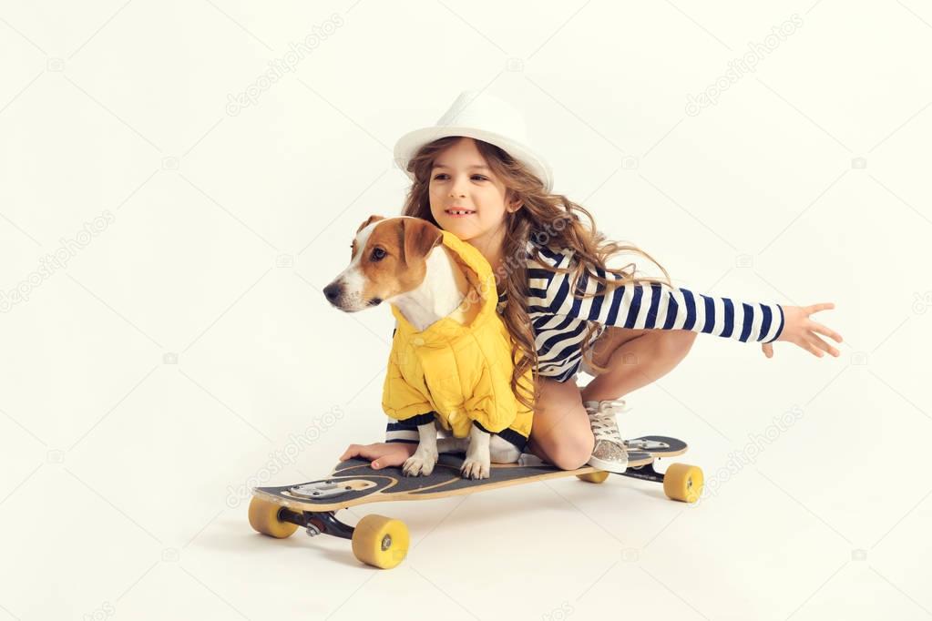 Girl is skateboarding with dog