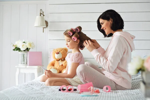 Madre está rizando el pelo de su hija — Foto de Stock