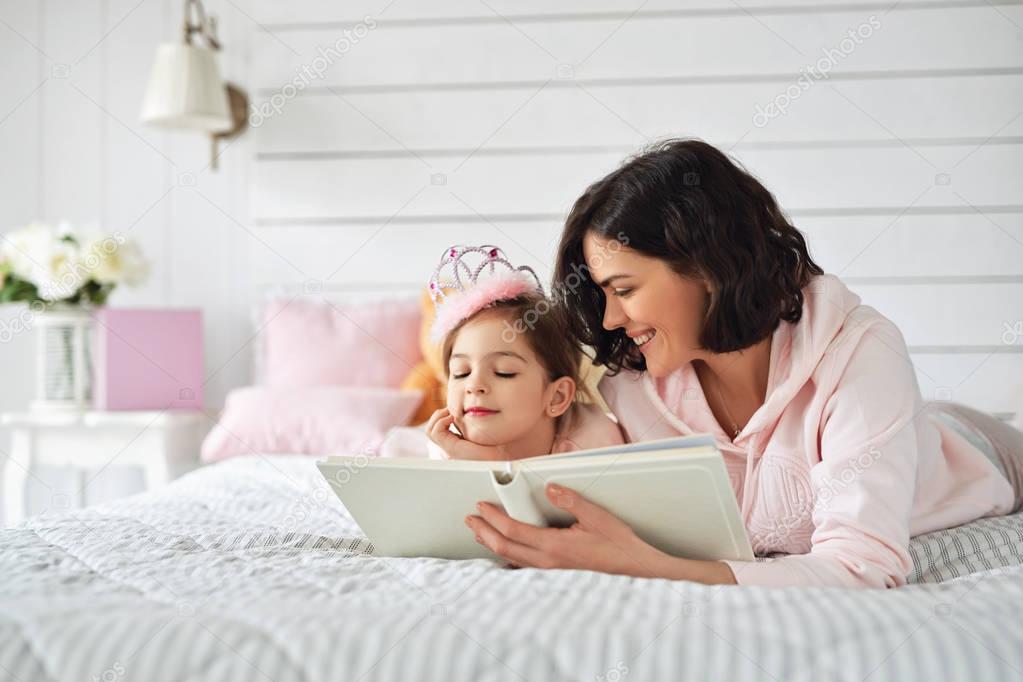 Mother is reading a book to her daughter