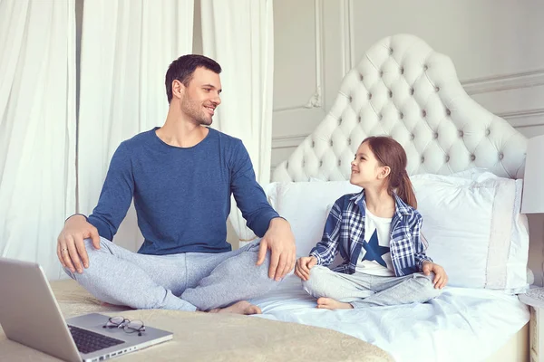 Папа и его дочь сидят на кровати — стоковое фото