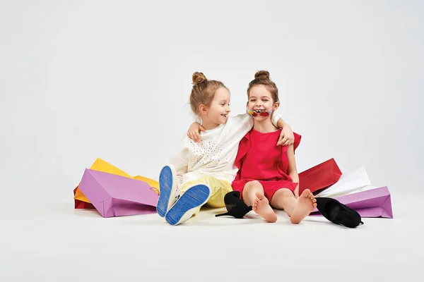 Las chicas riendo están sentadas con bolsas de los compradores — Foto de Stock