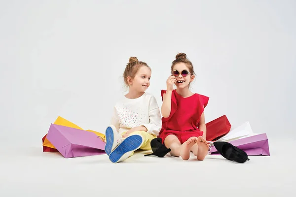 Vestido chicas están sentados alrededor de shoppers bolsas — Foto de Stock