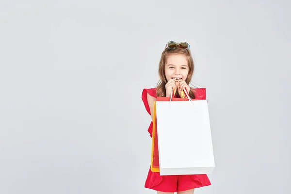Маленькая девочка держит сумки покупателей — стоковое фото