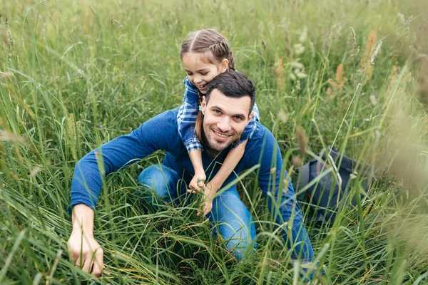 Neşeli kız onunla birlikte zaman geçirmek sevindim yeşil yaz sahada yürüyor babası kucaklayan. Yakışıklı adam açık havada dinlenme, güzel doğa hayran kızı ile — Stok fotoğraf
