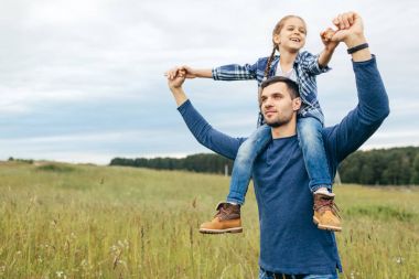 Aile birlikte vakit. Sırtımda sahip güzel doğa manzara yürüyüş yaparken küçük kızını vererek mutlu baba. Gülümseyen kızı ve babası iyi ilişkileri olan