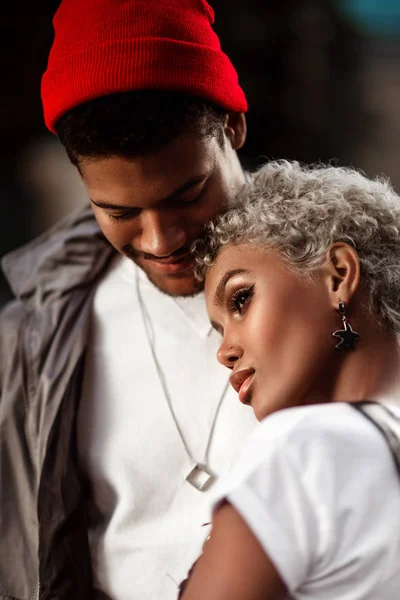 Modaya uygun saç modeli ve dalgın bakmak tribünlere yakından onun koyu tenli erkek kırmızı şapkalı güzel kadın melez bardak kadar yakın, gerçek sevgi ve iyi bir ilişki göstermektedir. Etnik Yapı ve insanlar.