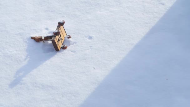 Giocattolo da bambini sdraiato nella neve e la donna lo prende. Piccolo pupazzo di neve giocattolo nella neve. Mano prendere giocattolo di Natale retrò colorato scatola neve invernale. Una cosa vintage su una borsa bianca. Inverno — Video Stock