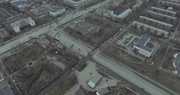 Aerial survey na miasto. Widok z nieba na rosyjskie miasto. Miasto z lotu ptaka widok na domy, ulice i parki. Szare niebo i garaże naprawdę mieszkaniowej dzielnicy. Aerial survey na ulicy gdzie jeździć dużo — Wideo stockowe