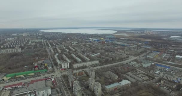 Flygfotografering på staden. Visa från himlen på ryska staden. Aerial stadsutsikt på hus, gator och parker. Grå himmel och garage riktigt bostadsområde. Flygfotografering på gatan där kör mycket — Stockvideo