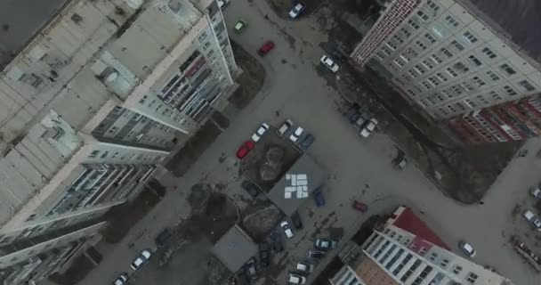 Encuesta aérea en la ciudad. Vista desde el cielo de la ciudad rusa. Vista aérea de la ciudad sobre casas, calles y parques. Cielo gris y garajes barrio realmente residencial. Estudio aéreo en la calle donde se conduce mucho — Vídeos de Stock