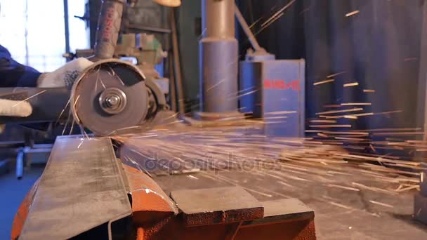 Artesano aserrado de metal con amoladora de disco en taller. Aserrado de metal de cerca. Trabajador en la producción de aserrado de metal. Procesamiento de metal, hierro. trabajador en la máquina. Trabajador de corte de metal con un metal — Vídeos de Stock